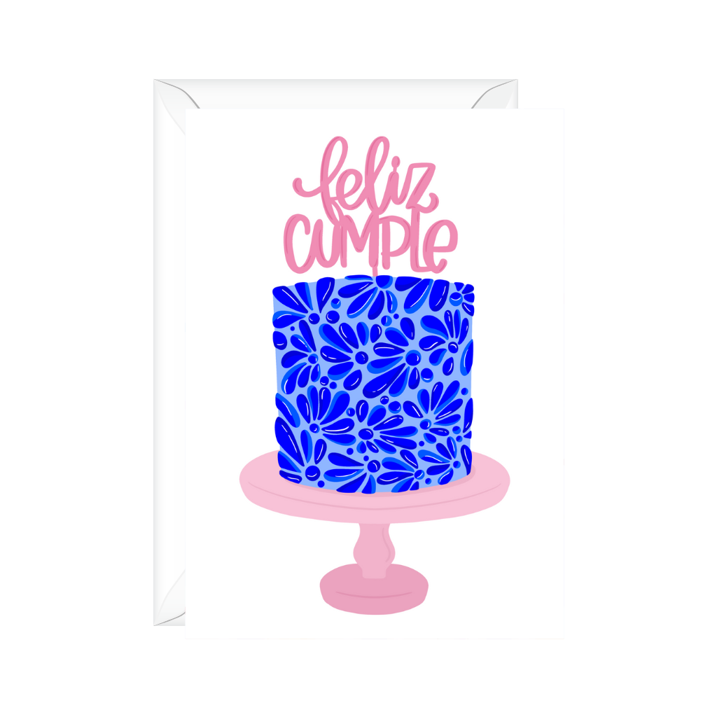 Feliz Cumpleanos blue mexican themed frosted cake on pink cake stand with feliz cumple pink cake topper to celebrate Spanish birthday.